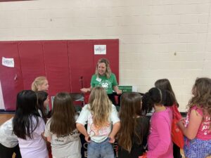 4-H Agent at an information booth promoting 4-H to school children